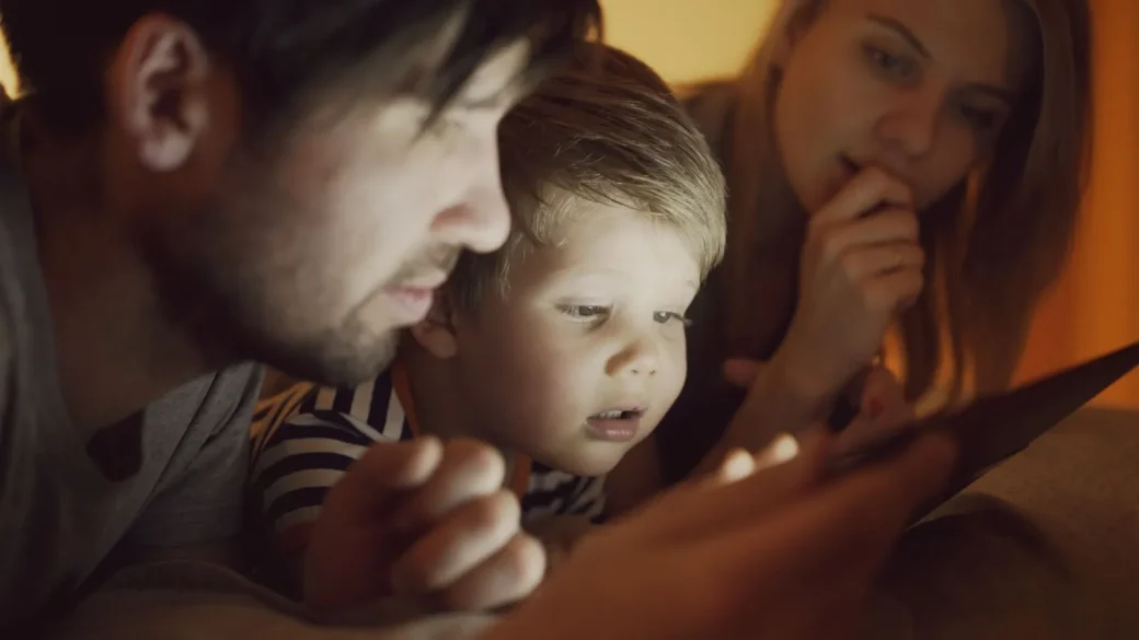 a parent and young child looking at a tablet together