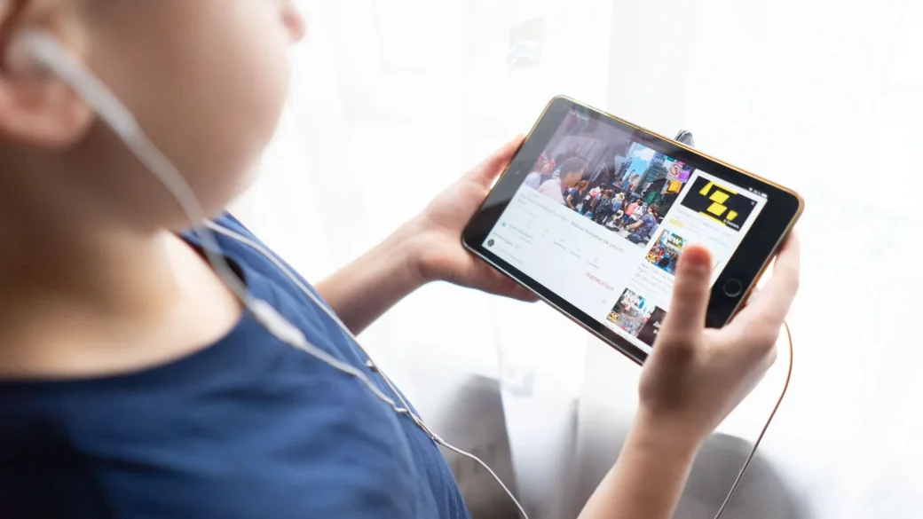 small hands holding a tablet with a child app open