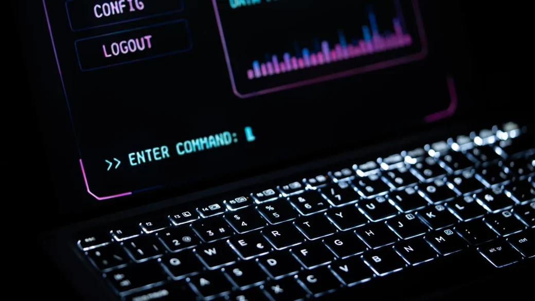 a person carefully working on a laptop at a tidy desk