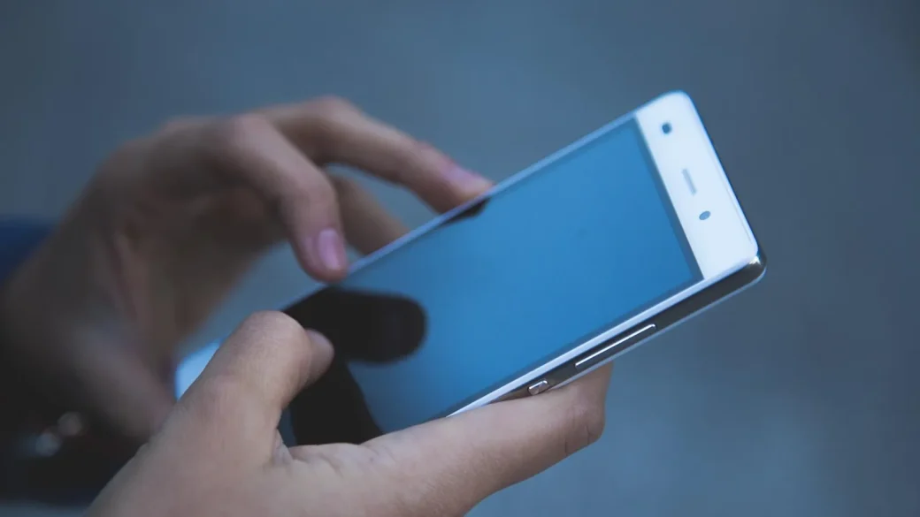 finger tapping a report phishing button in an email app