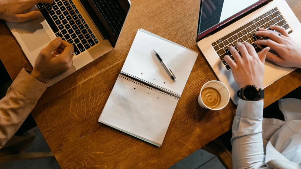 a Windows laptop and a MacBook on a desk